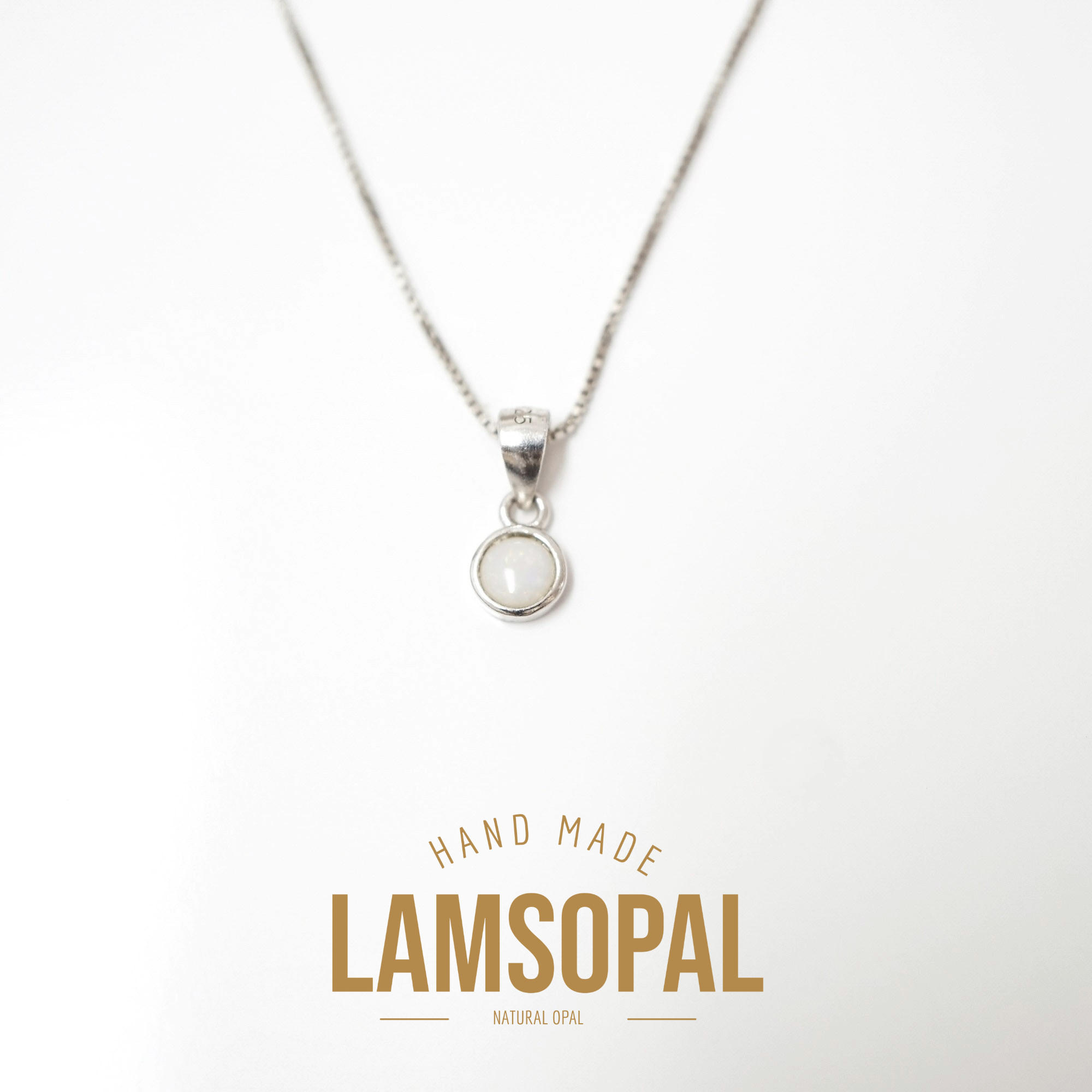 A silver necklace with a small circular pendant containing a white natural opal, displayed on a clean white background with a gold-colored 'LAMSOPAL' brand logo at the bottom.
