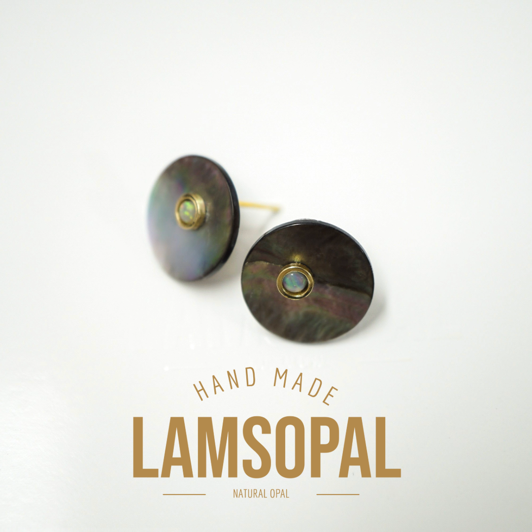 A pair of handmade Lamsopal natural opal stud earrings with iridescent shell discs and gold settings, displayed on a clean white background with text overlay.