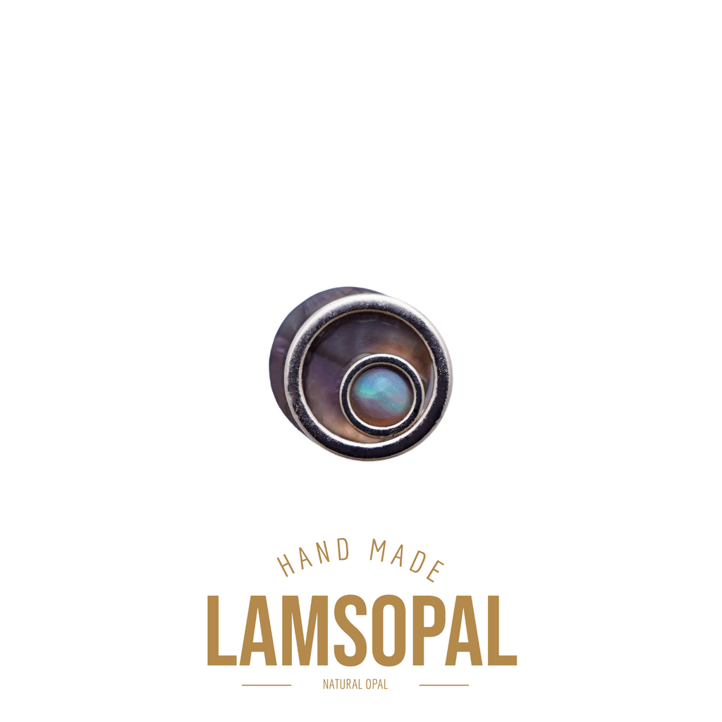 A single round labret piercing stud featuring a natural iridescent lamsonopal (natural opal) center, shown with branding text below on a solid white background.