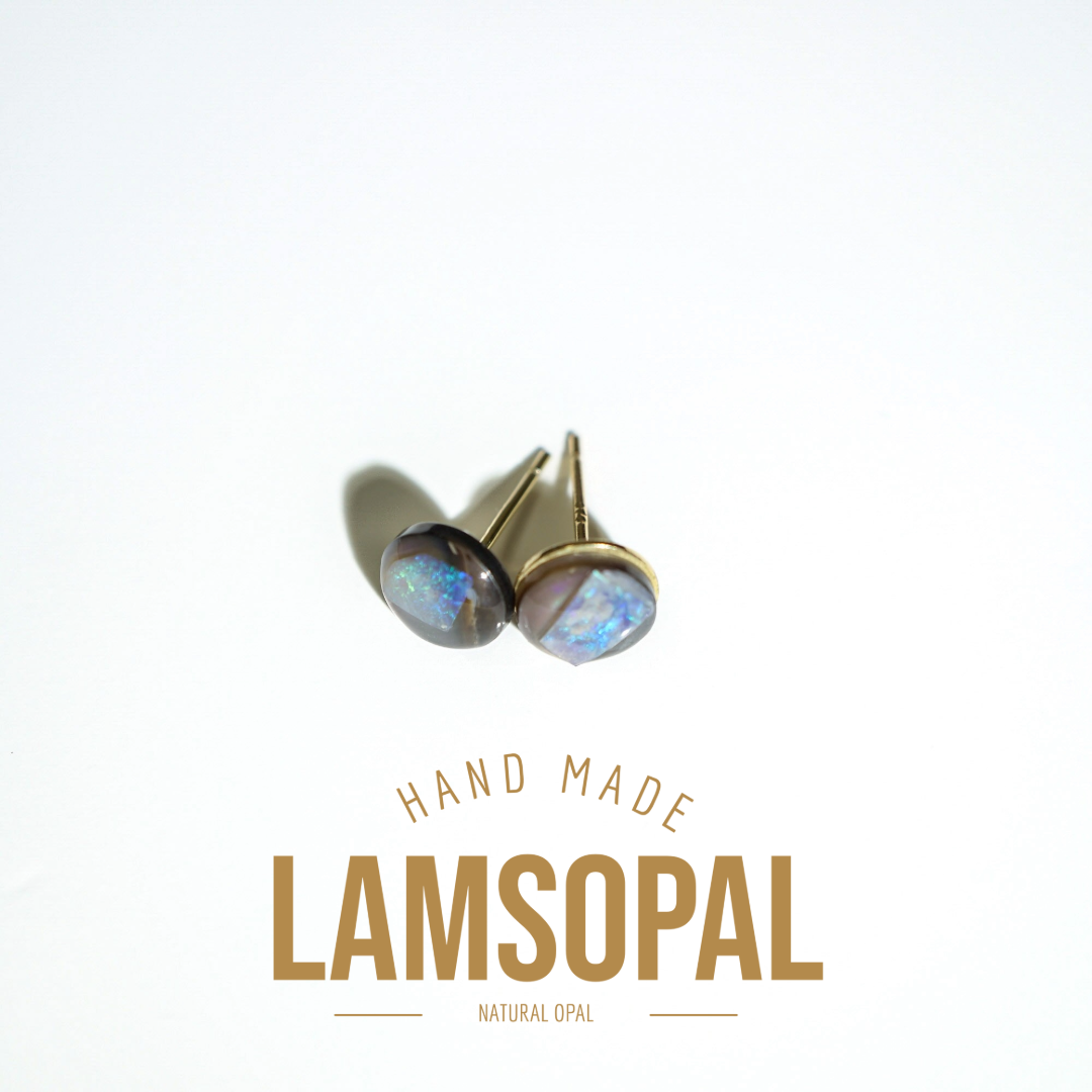 A pair of Lamsopal natural opal stud earrings with gold settings, displayed on a clean white background with a soft shadow. Below the earrings, the text 'HAND MADE LAMSOPAL NATURAL OPAL' is written in a gold-colored font.