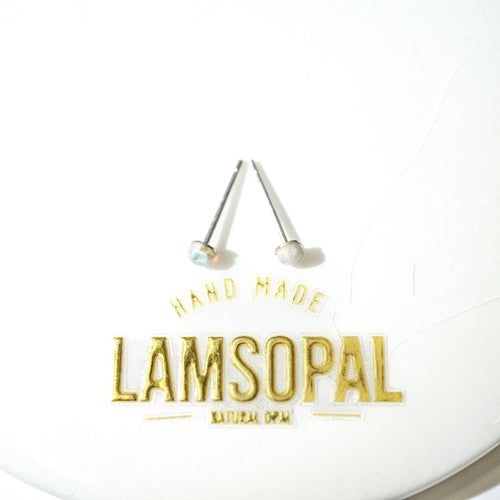 A pair of Lamsopal natural opal stud earrings with silver posts and round iridescent opal gemstones, displayed on a white circular backing card with gold foil branding.