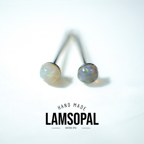 A pair of Lamsopal natural opal stud earrings with silver-toned posts and round, iridescent opal cabochons, displayed on a clean white background with a brand logo overlay at the bottom.