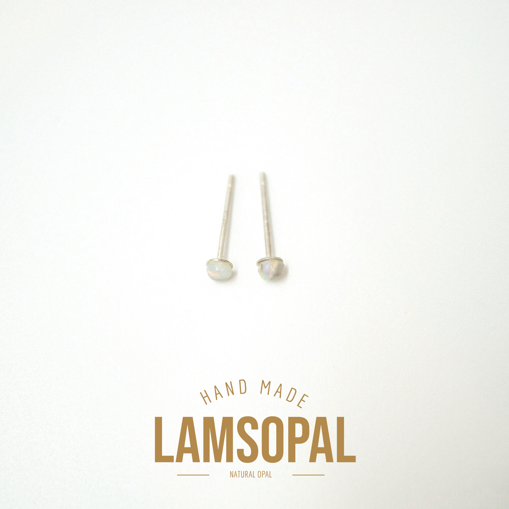 Two small natural opal stud earrings with silver posts, displayed on a clean white background with a gold 'LAMSOPAL' brand logo and 'HAND MADE' text below.