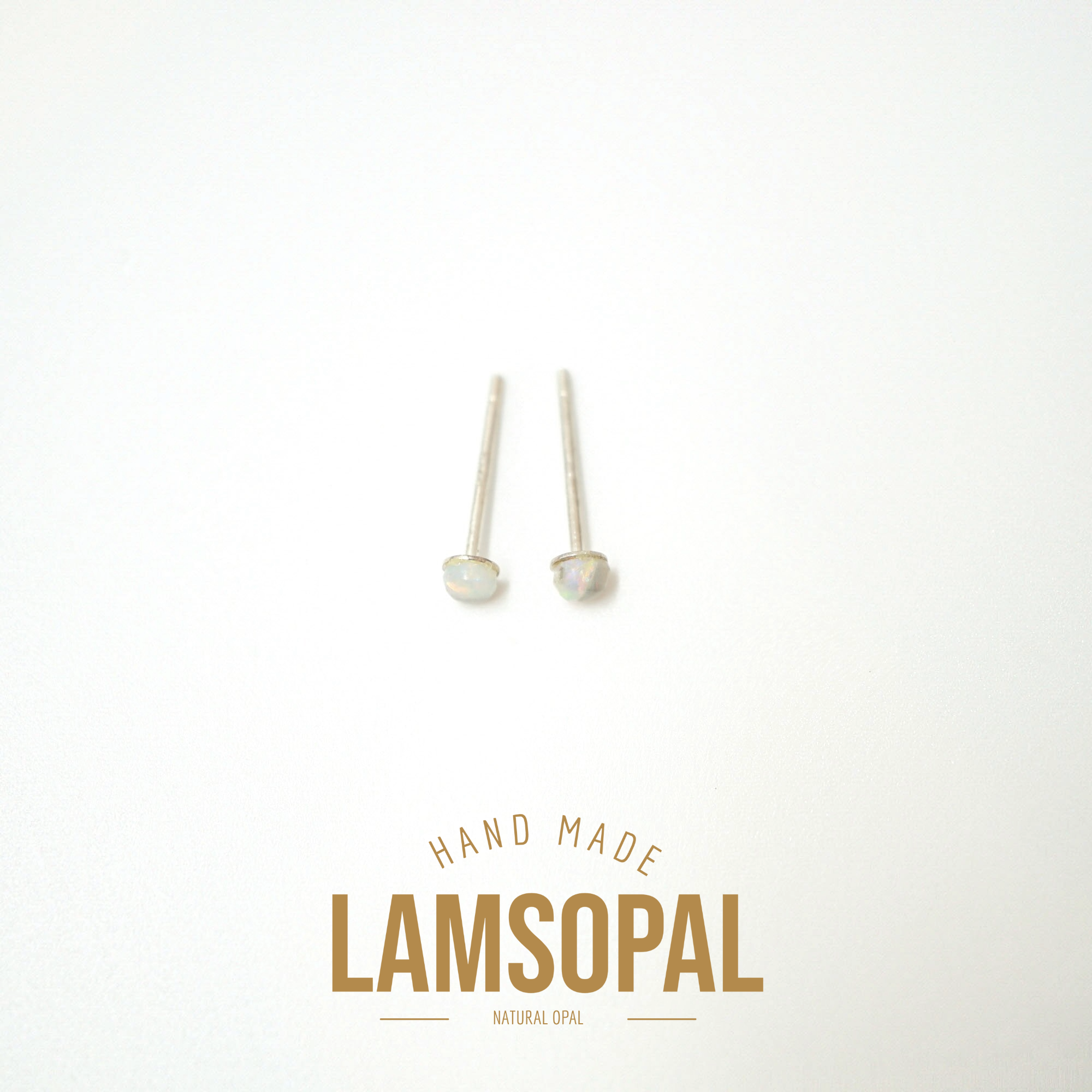Two small natural opal stud earrings with silver posts, displayed on a clean white background with a gold 'LAMSOPAL' brand logo and 'HAND MADE' text below.