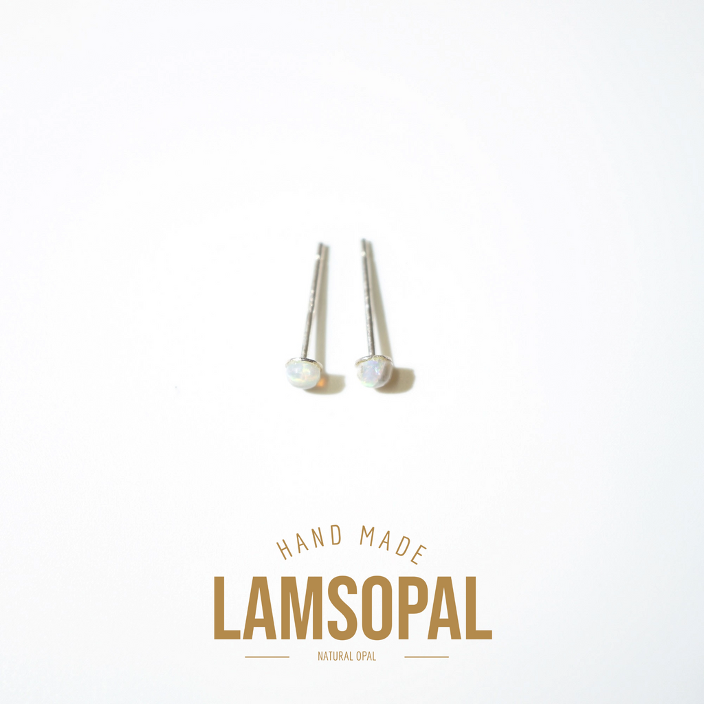 A pair of silver post earrings with round iridescent opal cabochons, displayed on a clean white background with a gold 'LAMSOPAL' brand logo and 'HAND MADE' text below.
