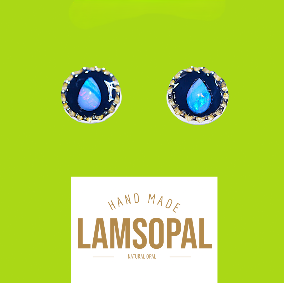A pair of Lamsopal natural opal stud earrings with teardrop-shaped blue opal centers in silver bezel settings, displayed on a bright lime green background with a white label below reading 'HAND MADE LAMSOPAL NATURAL OPAL'.