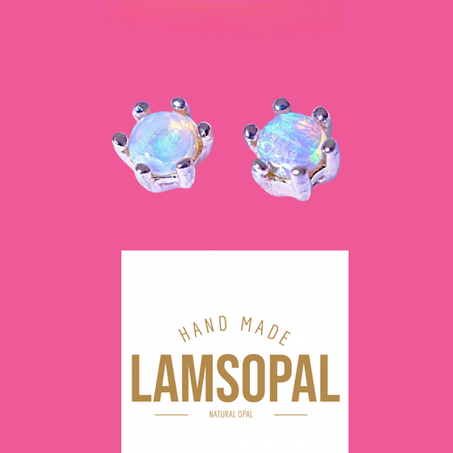 A pair of Lamsopal natural opal stud earrings set in silver, displayed on a vibrant pink background with a white brand card below.