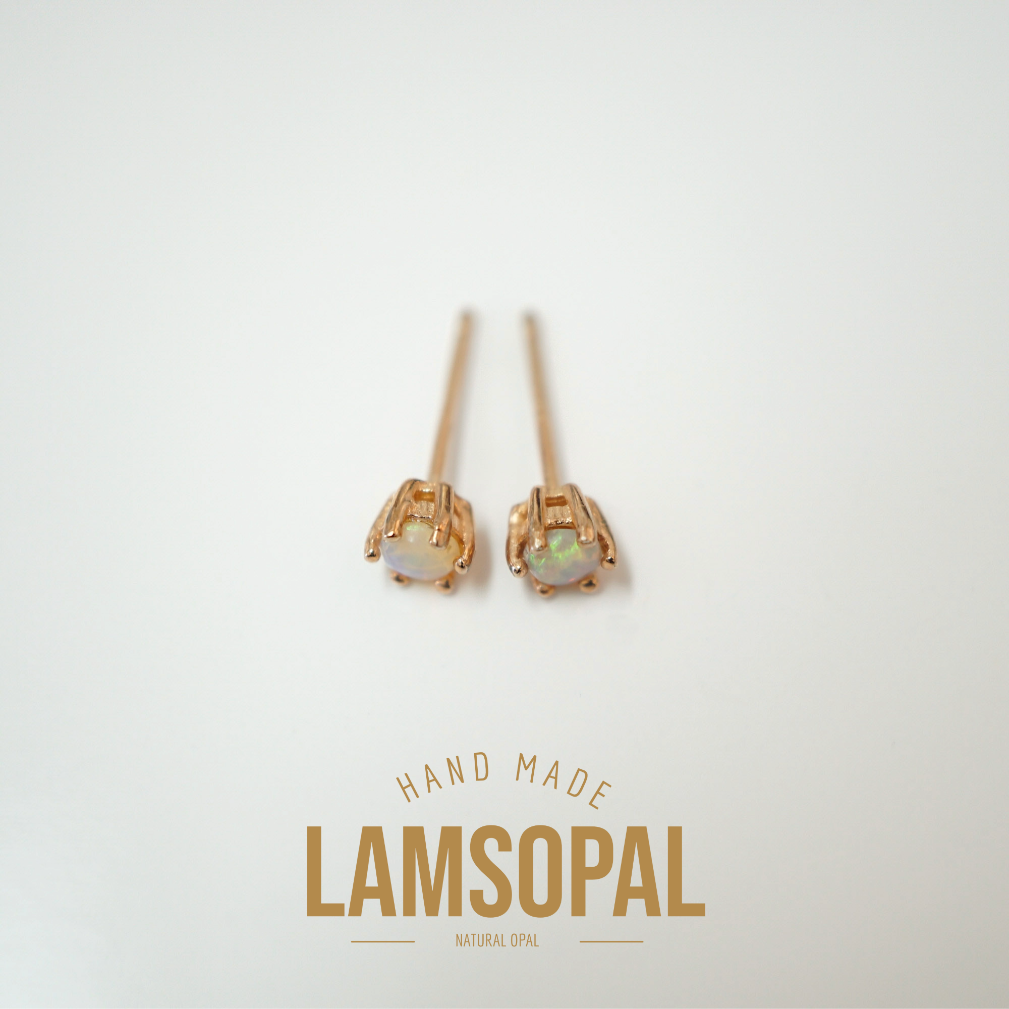 A pair of Lamsopal handmade natural opal stud earrings in a rose gold setting, displayed on a clean off-white background with a gold brand logo below.
