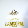 A pair of gold-toned stud earrings with circular concentric oval designs and natural opal inlays, displayed on a white surface above a gold 'LAMSOPAL' brand logo.