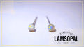 A pair of Lamsopal natural opal stud earrings with silver posts, displayed on a light lavender background with a gold border and a brand logo overlay in the bottom right corner.