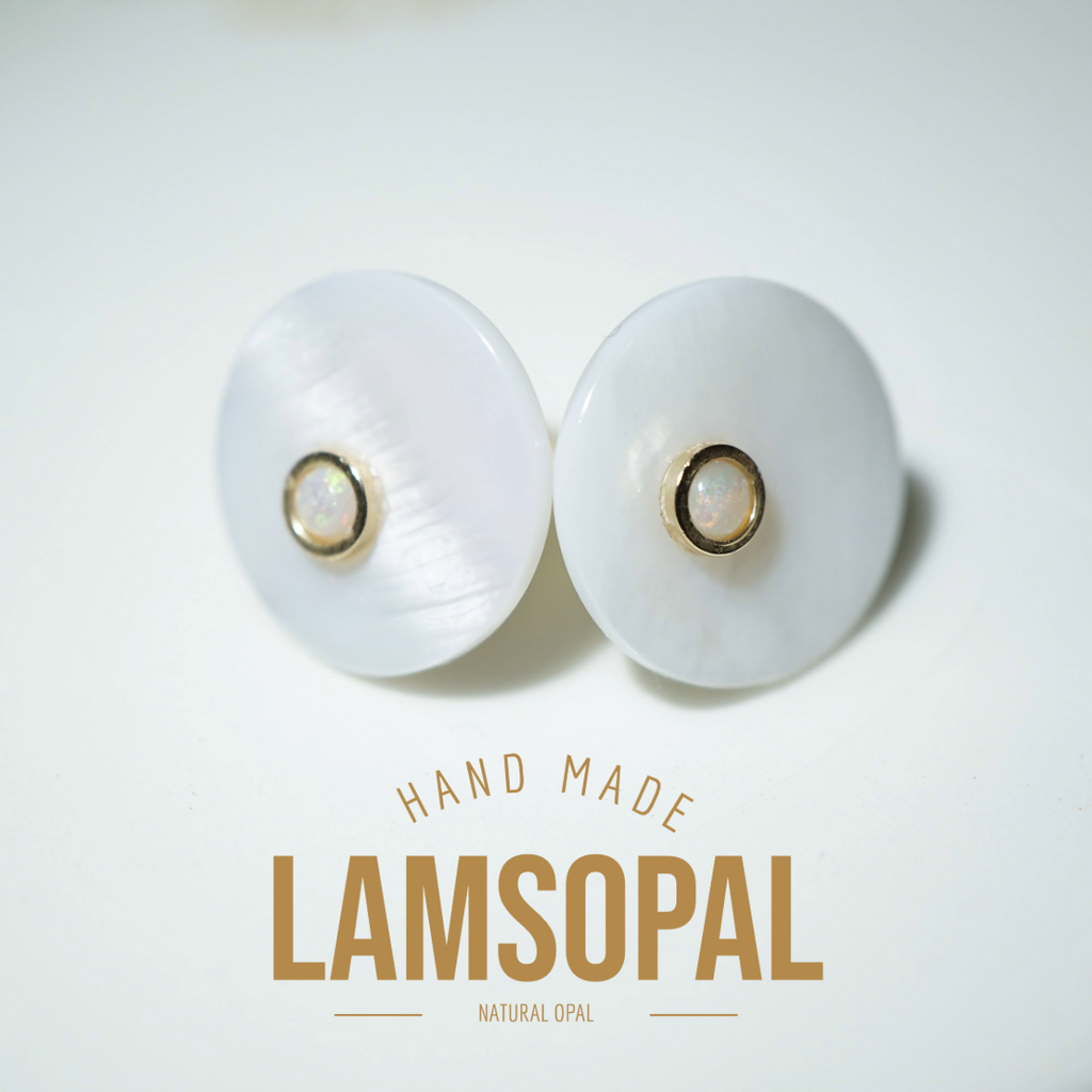 A pair of handmade Lamsopal natural opal stud earrings with round white mother-of-pearl discs and gold bezel-set opal centers, displayed on a clean white background with 'HAND MADE LAMSOPAL' text below.