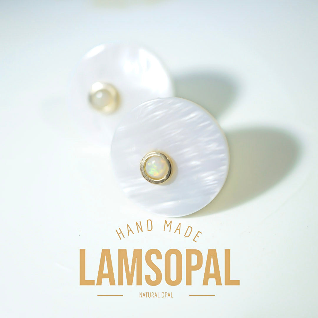 A pair of handmade Lamsopal natural opal stud earrings with round white mother-of-pearl discs and gold bezel-set iridescent opal centers, displayed on a clean white background with 'HAND MADE LAMSOPAL' text below.