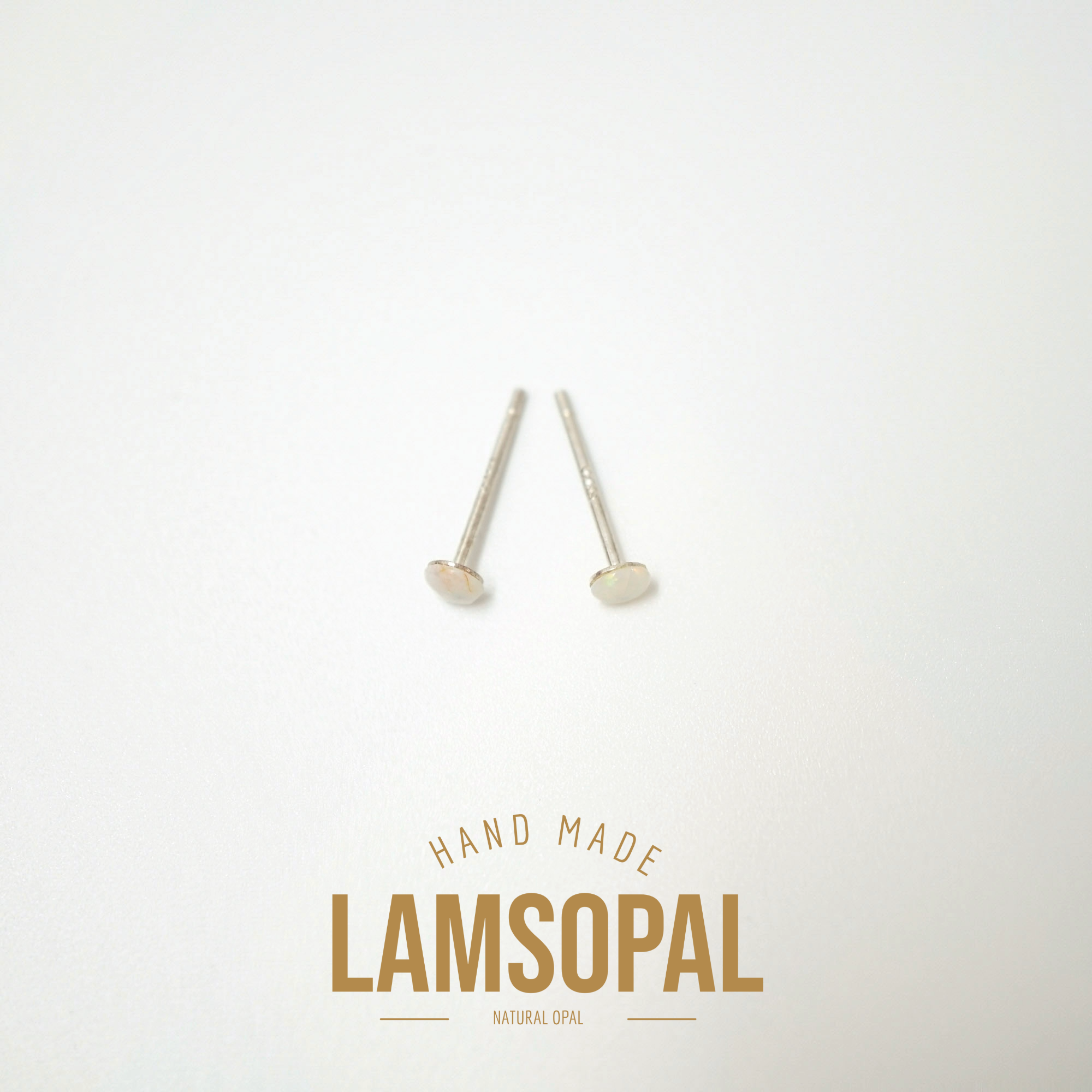Two small silver-toned natural opal stud earrings on a clean white background, with the brand name 'LAMSOPAL' and 'HAND MADE' printed below.