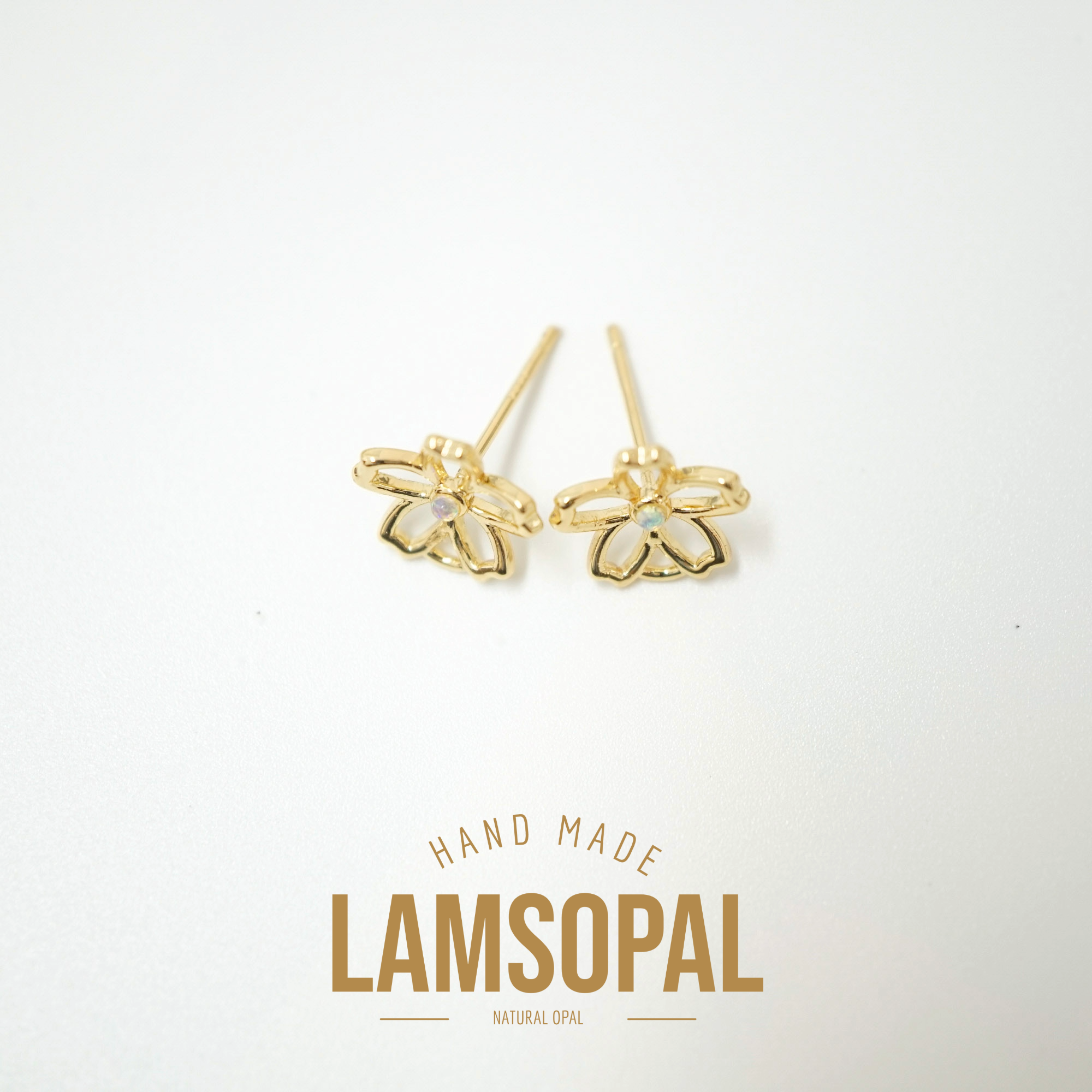 A pair of gold bee stud earrings with small white inlay details, displayed on a clean white background with a gold 'LAMSOPAL' brand logo below.