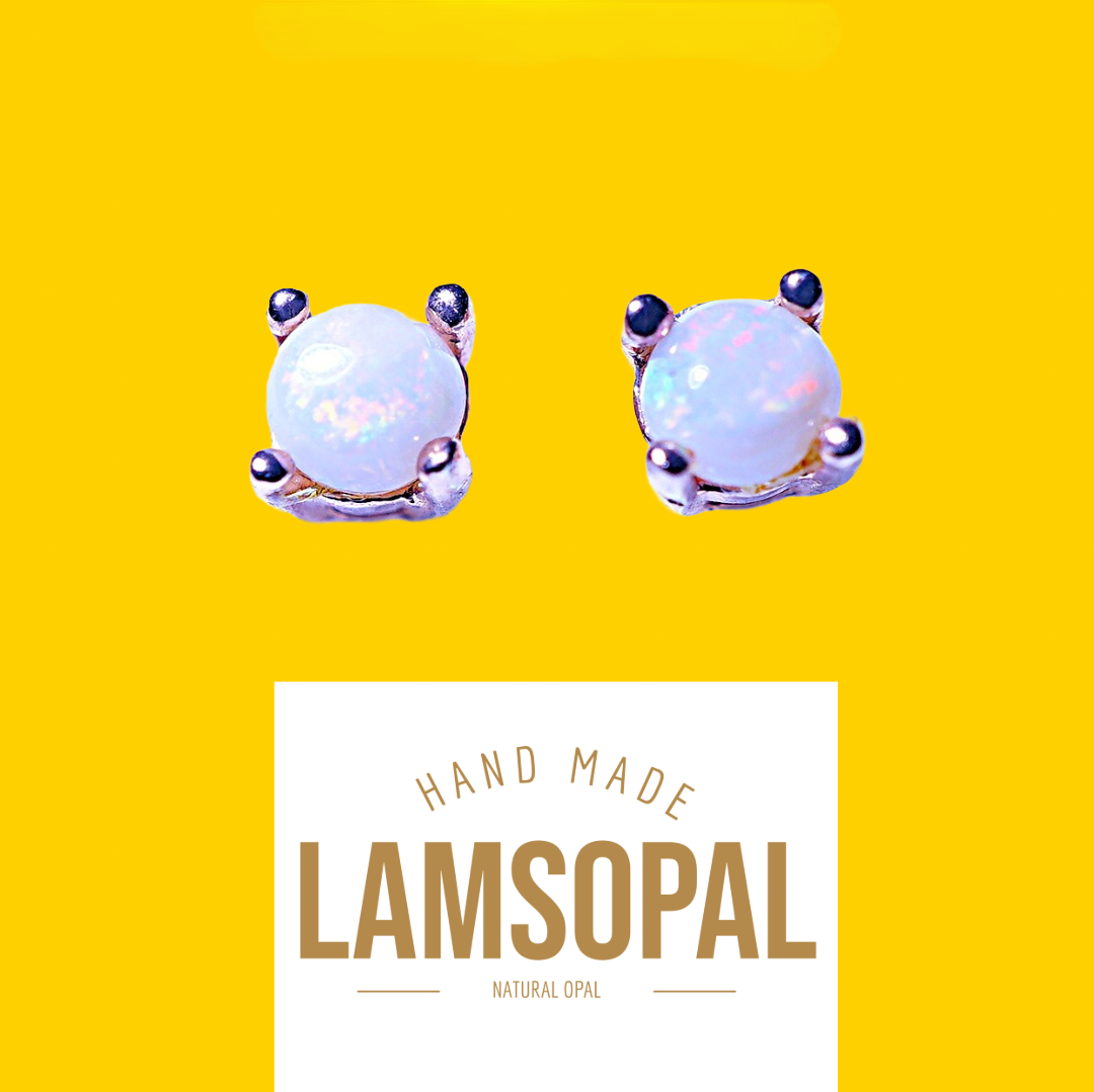 A pair of Lamsopal hand-made natural opal stud earrings in a silver-toned setting, displayed on a bright yellow background with a white label below.