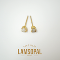 A pair of gold post earrings with oval white opal gemstones, displayed on a clean white background with a gold 'LAMSOPAL' brand logo and 'HAND MADE' text below.