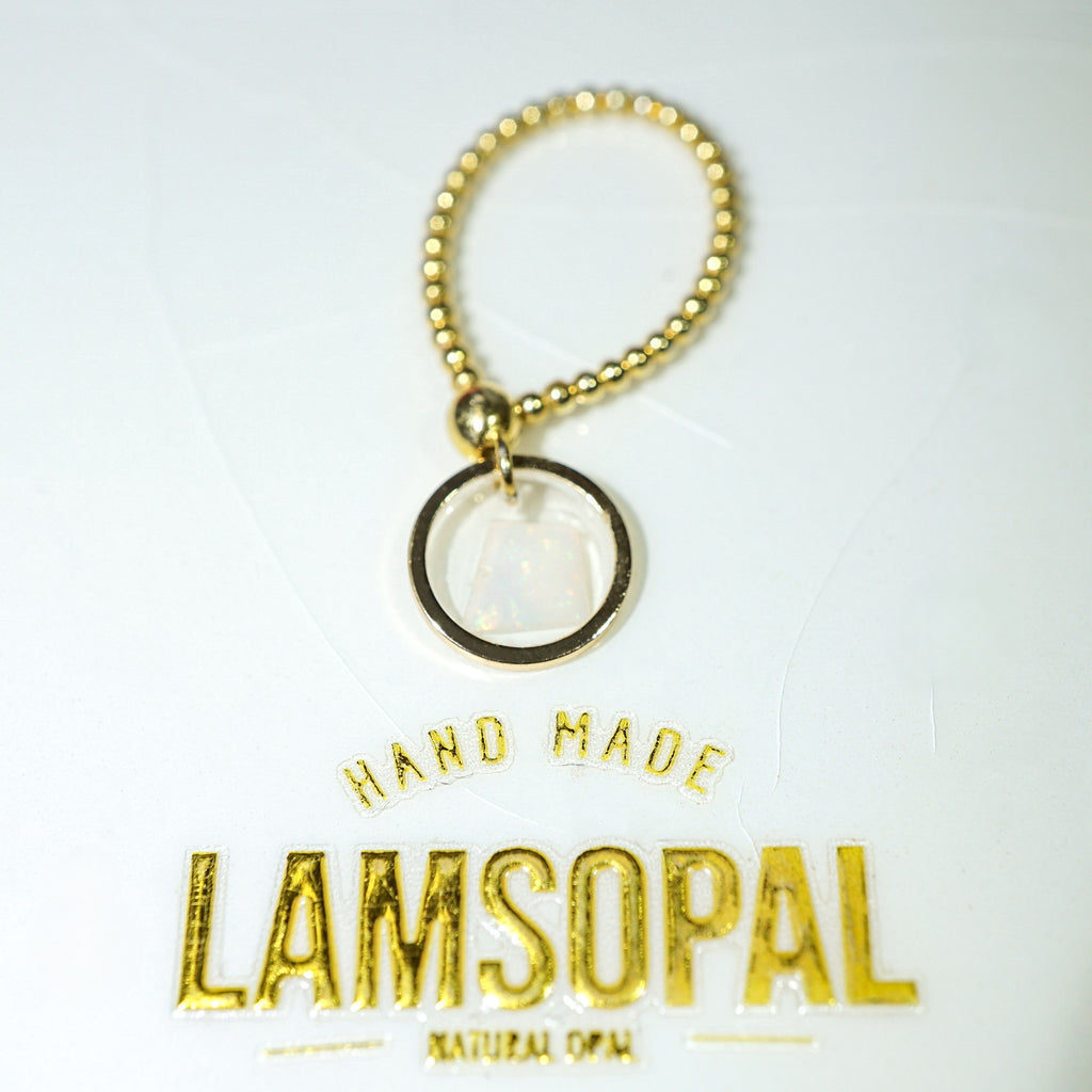 A gold-tone beaded keychain or bag charm with a circular pendant, shown on a white background with the brand name 'Lamsopal' printed below.