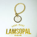 A gold-tone beaded keychain or bag charm with a circular pendant, shown on a white background with the brand name 'Lamsopal' printed below.