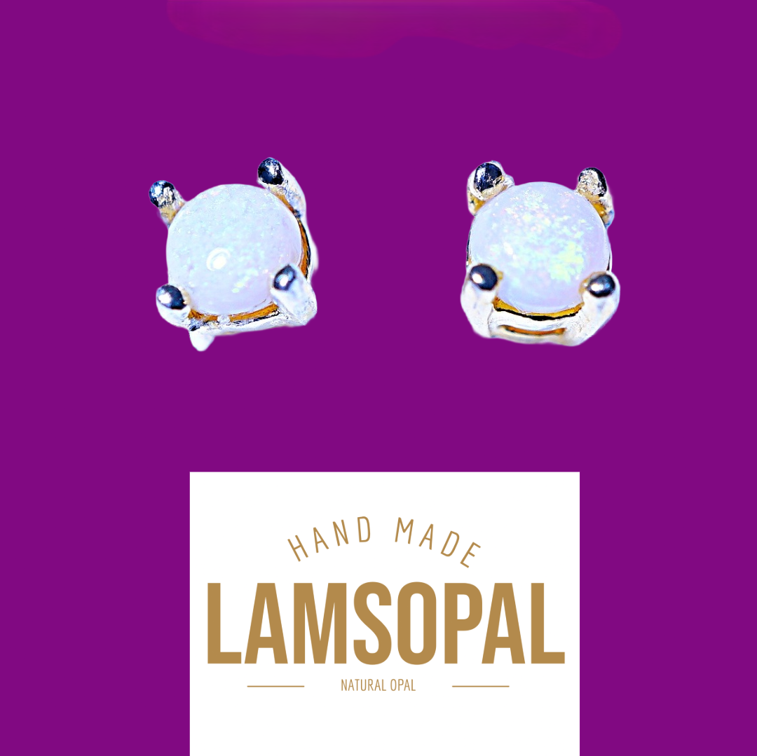 Two handmade Lamsopal natural opal stud earrings with gold and silver settings, displayed on a purple background with a white label below reading 'HAND MADE LAMSOPAL NATURAL OPAL'.