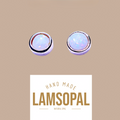 Two round natural opal stud earrings with silver bezels, shown above a white label that reads 'HAND MADE LAMSOPAL NATURAL OPAL' on a solid tan background.