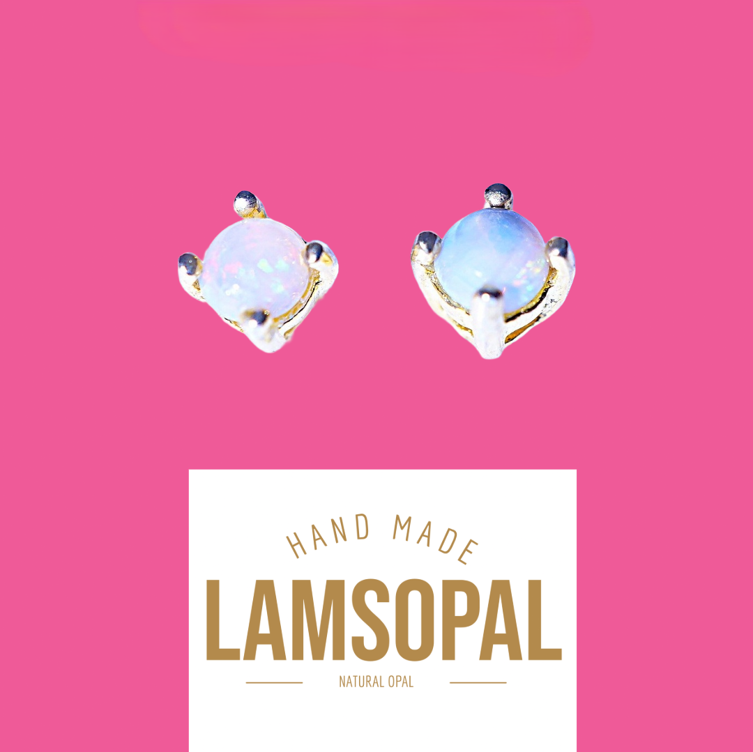 A pair of handmade Lamsopal natural opal stud earrings with gold settings, displayed on a vibrant pink background with a white label below that reads 'HAND MADE LAMSOPAL NATURAL OPAL'.