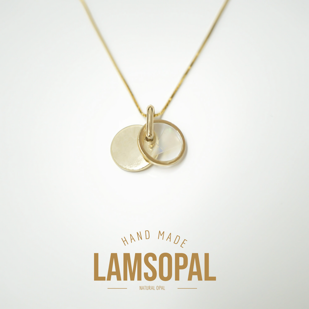 A gold disc pendant necklace with two overlapping circular pendants on a thin chain, shown against a light gray background with the text 'HAND MADE LAMSOPAL NATURAL OPAL' below.