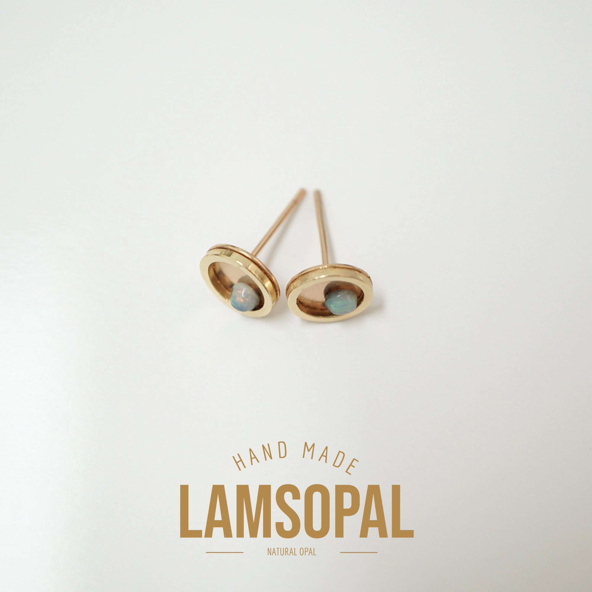 A pair of gold oval stud earrings with natural blue opal inlays, displayed on a clean white background with 'HAND MADE LAMSOPAL NATURAL OPAL' text below.