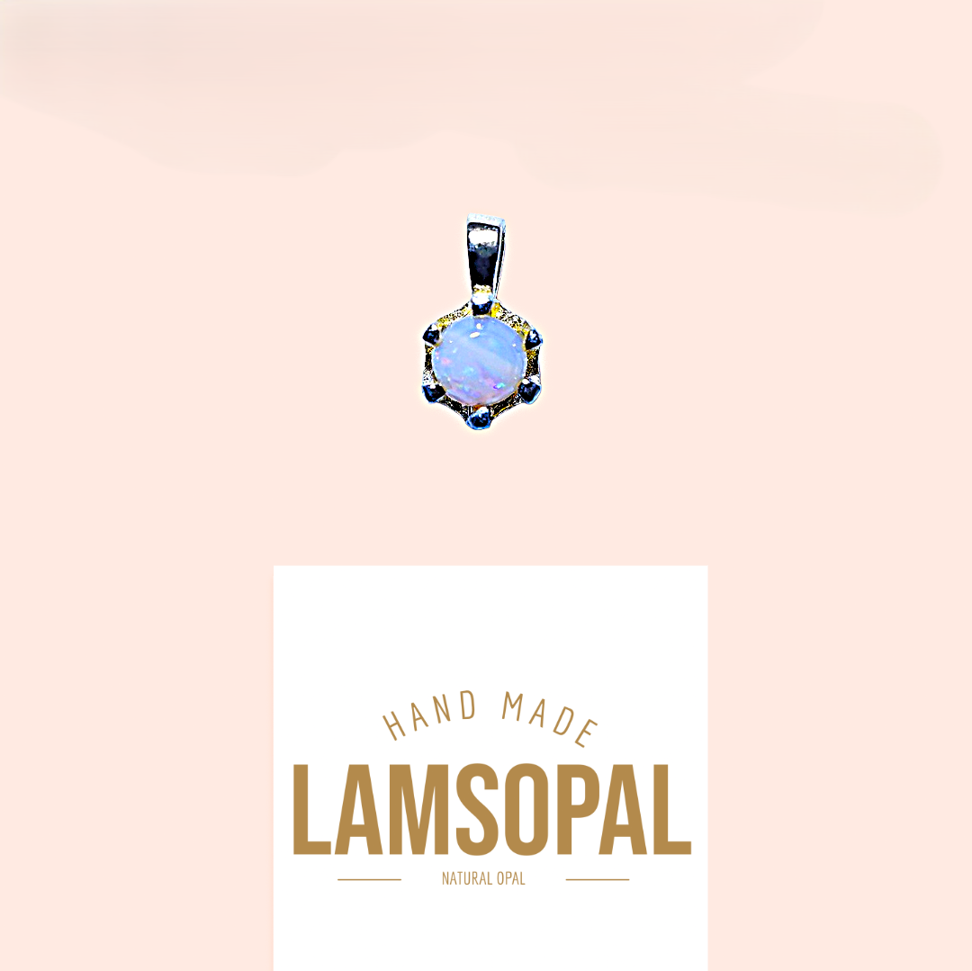 A silver pendant with a round iridescent blue opal center and small dark blue stones, shown above a white card that reads 'HAND MADE LAMSOPAL NATURAL OPAL' on a pale peach background.