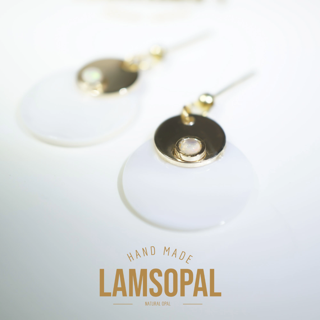 A pair of handmade Lamsopal natural opal dangle earrings with gold-plated circular discs and posts, displayed on a clean white background with a brand logo overlay at the bottom.