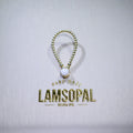 A gold-toned beaded key ring with a round white inlay, displayed above a gold foil brand stamp that reads 'HAND MADE LAMSOPAL'.