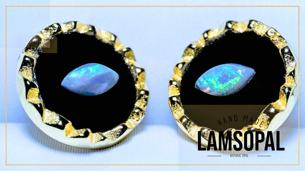 A pair of Lamsopal hand-made natural opal stud earrings with marquise-cut iridescent opal centers set in textured gold and silver bezels, displayed on a light blue background.