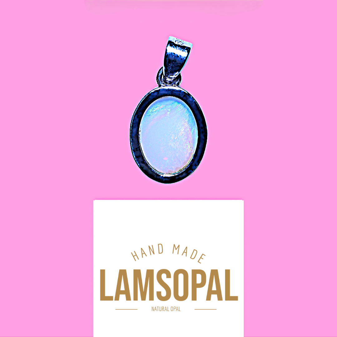 An oval pendant with a milky white opal center and a dark blue border, shown above a white card that reads 'HAND MADE LAMSOPAL NATURAL OPAL' on a solid pink background.