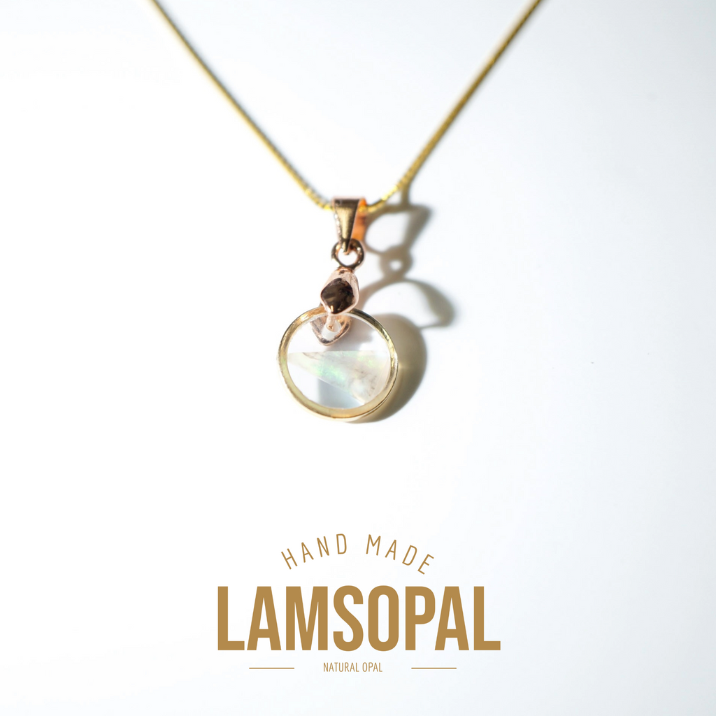 A gold chain necklace with a circular iridescent opal pendant in a rose gold setting, displayed on a clean white background with 'HAND MADE LAMSOPAL NATURAL OPAL' text below.