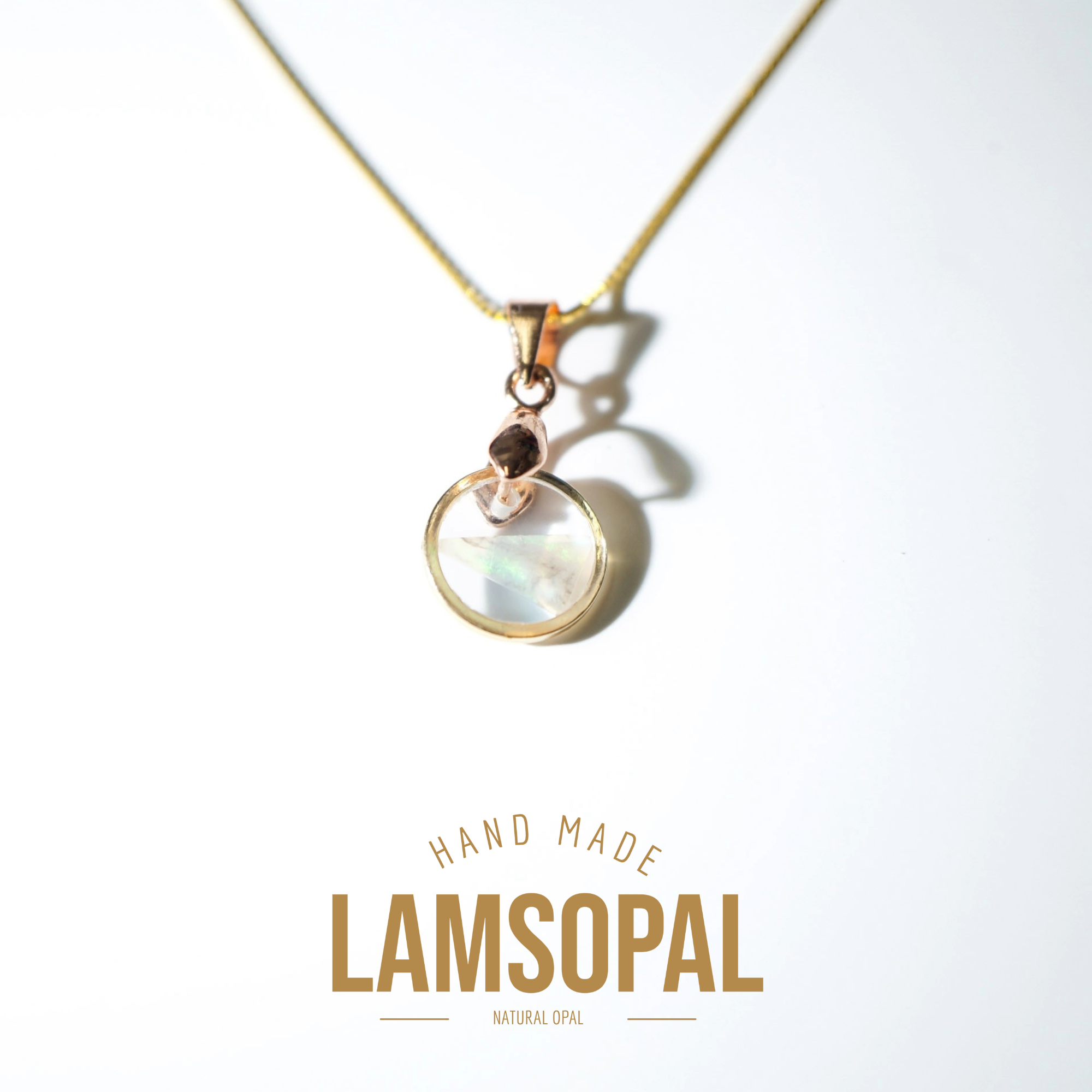 A gold chain necklace with a circular iridescent opal pendant in a rose gold setting, displayed on a clean white background with 'HAND MADE LAMSOPAL NATURAL OPAL' text below.