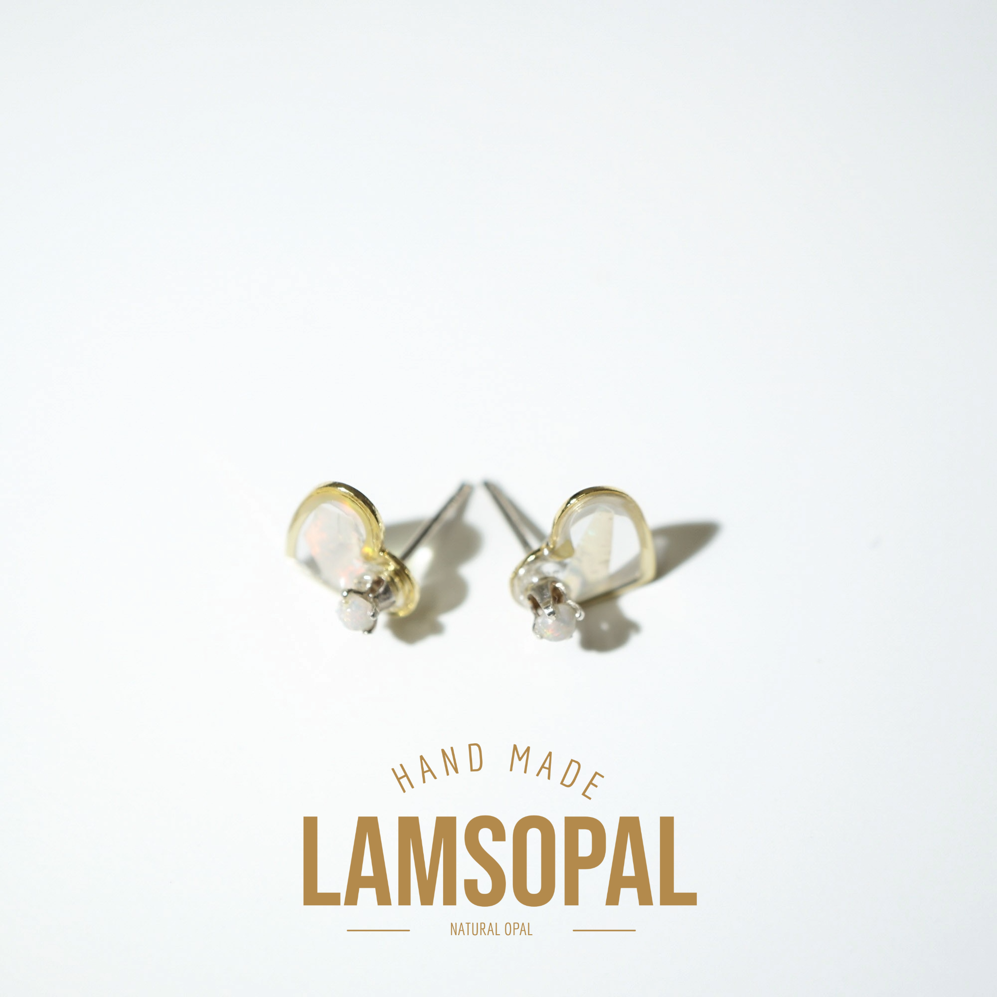 A pair of handmade Lamsopal natural opal stud earrings with gold and silver settings, displayed on a clean white background with a gold 'HAND MADE LAMSOPAL NATURAL OPAL' text overlay at the bottom.
