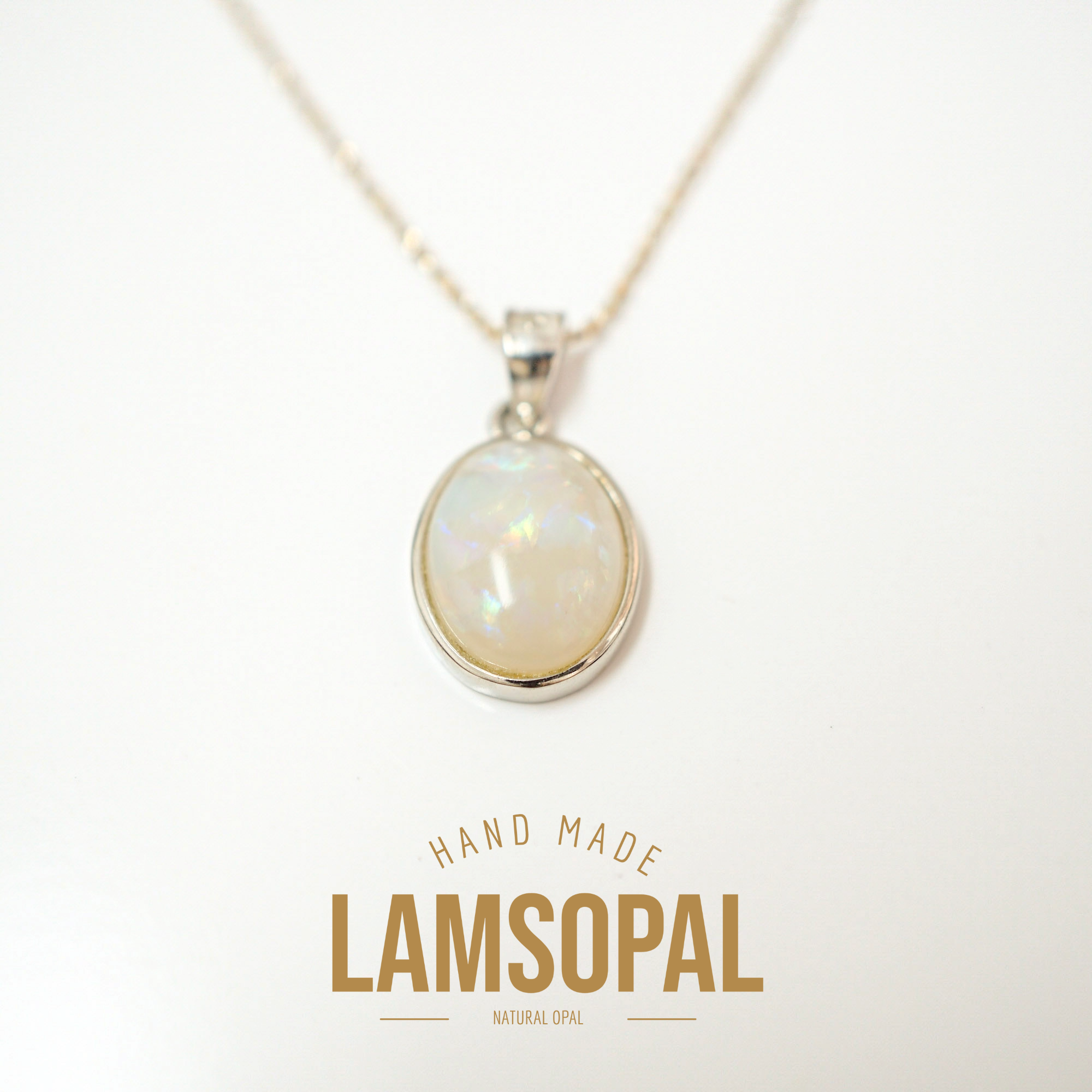 A silver necklace with an oval Lamsopal (natural opal) pendant, displayed on a clean white background with a gold-colored 'HAND MADE LAMSOPAL' text overlay at the bottom.
