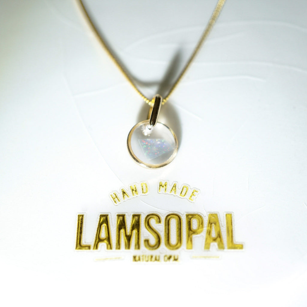 A gold necklace with a round bezel-set natural opal pendant, displayed on a white background with gold foil branding that reads 'HAND MADE LAMSOPAL'.