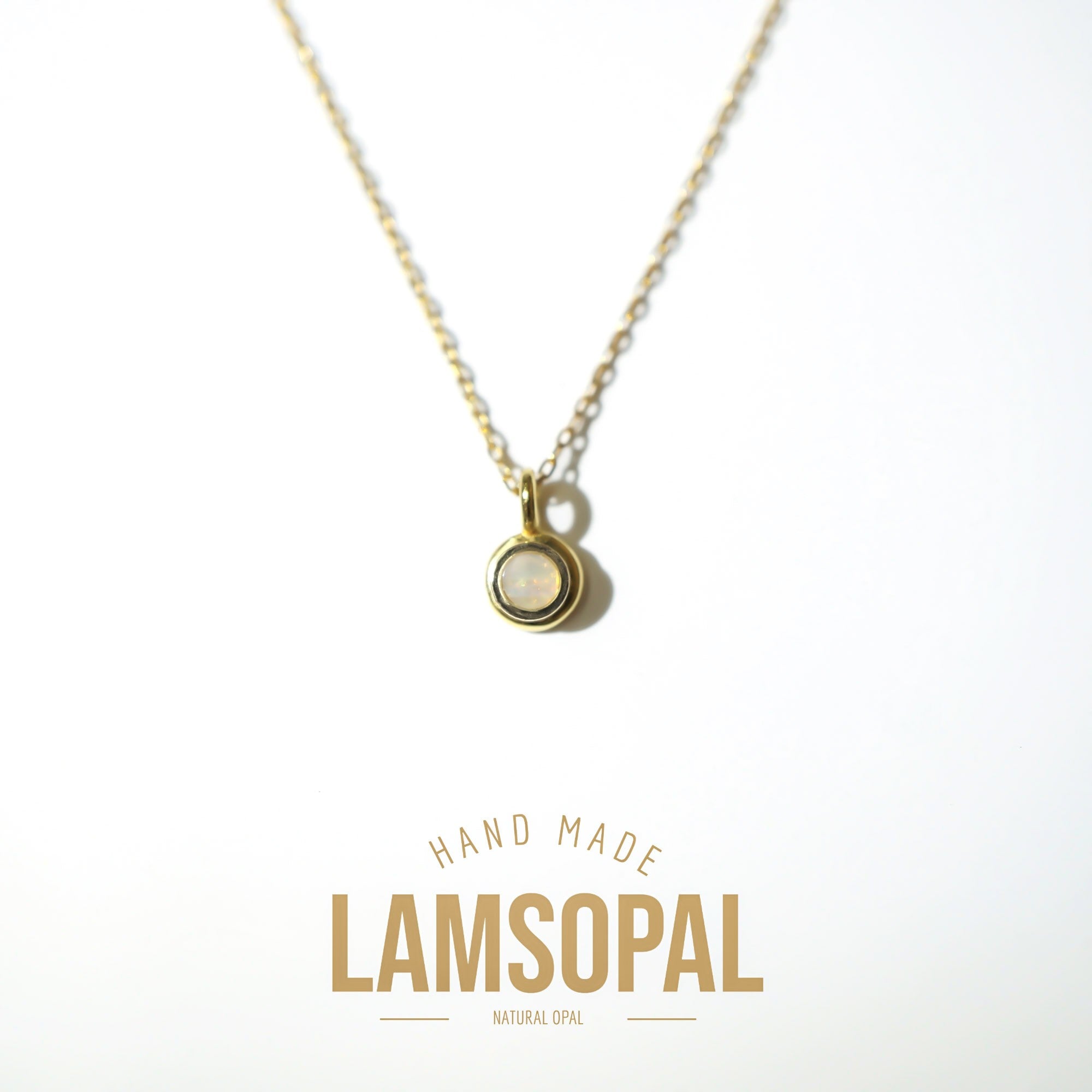 A gold chain necklace with a small oval pendant featuring a natural opal in a bezel setting, displayed on a clean white background with 'HAND MADE LAMSOPAL NATURAL OPAL' text below.