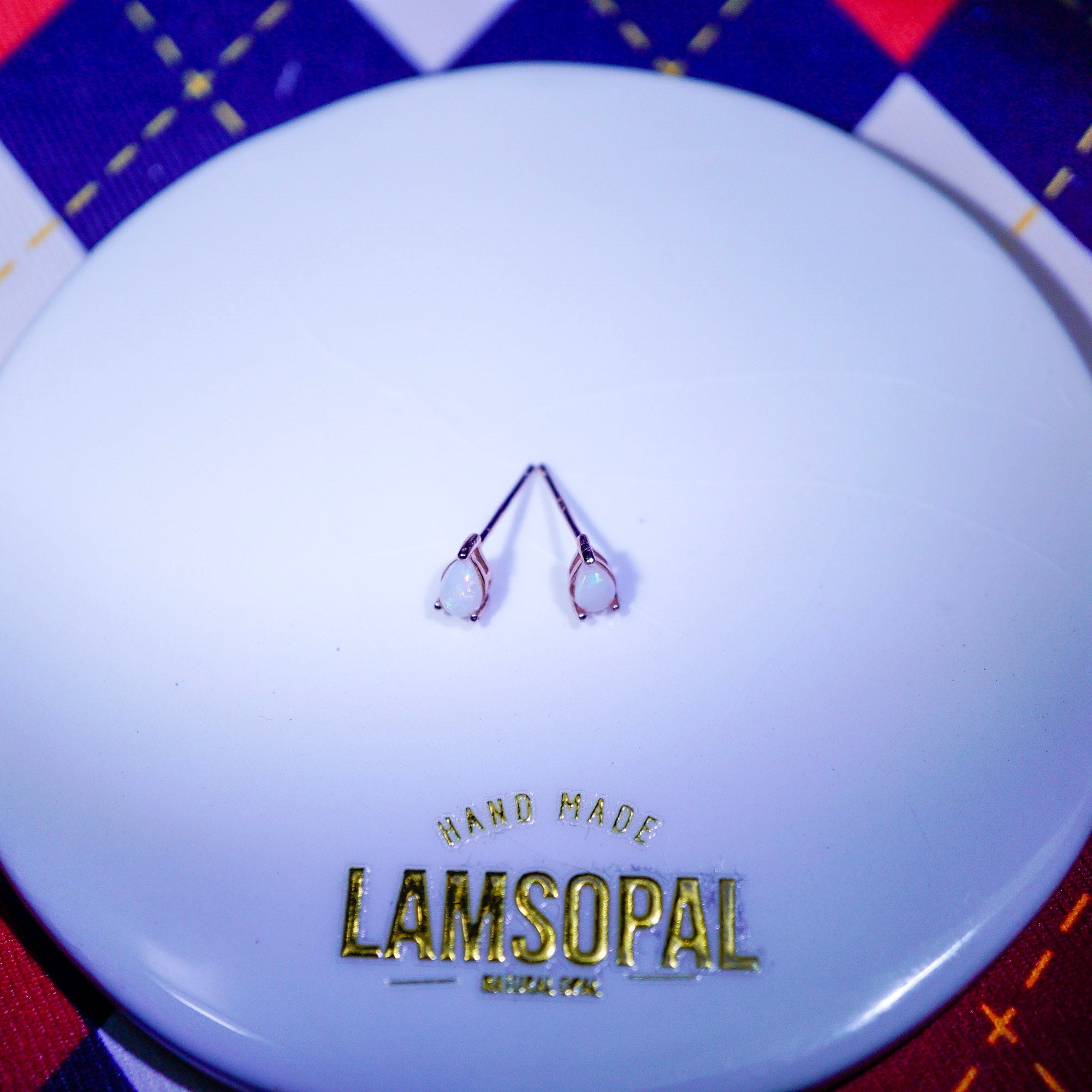 Rose gold plated teardrop Opal Earrings with 'LAMSOPAL Jewellery' branding white ceramic plate