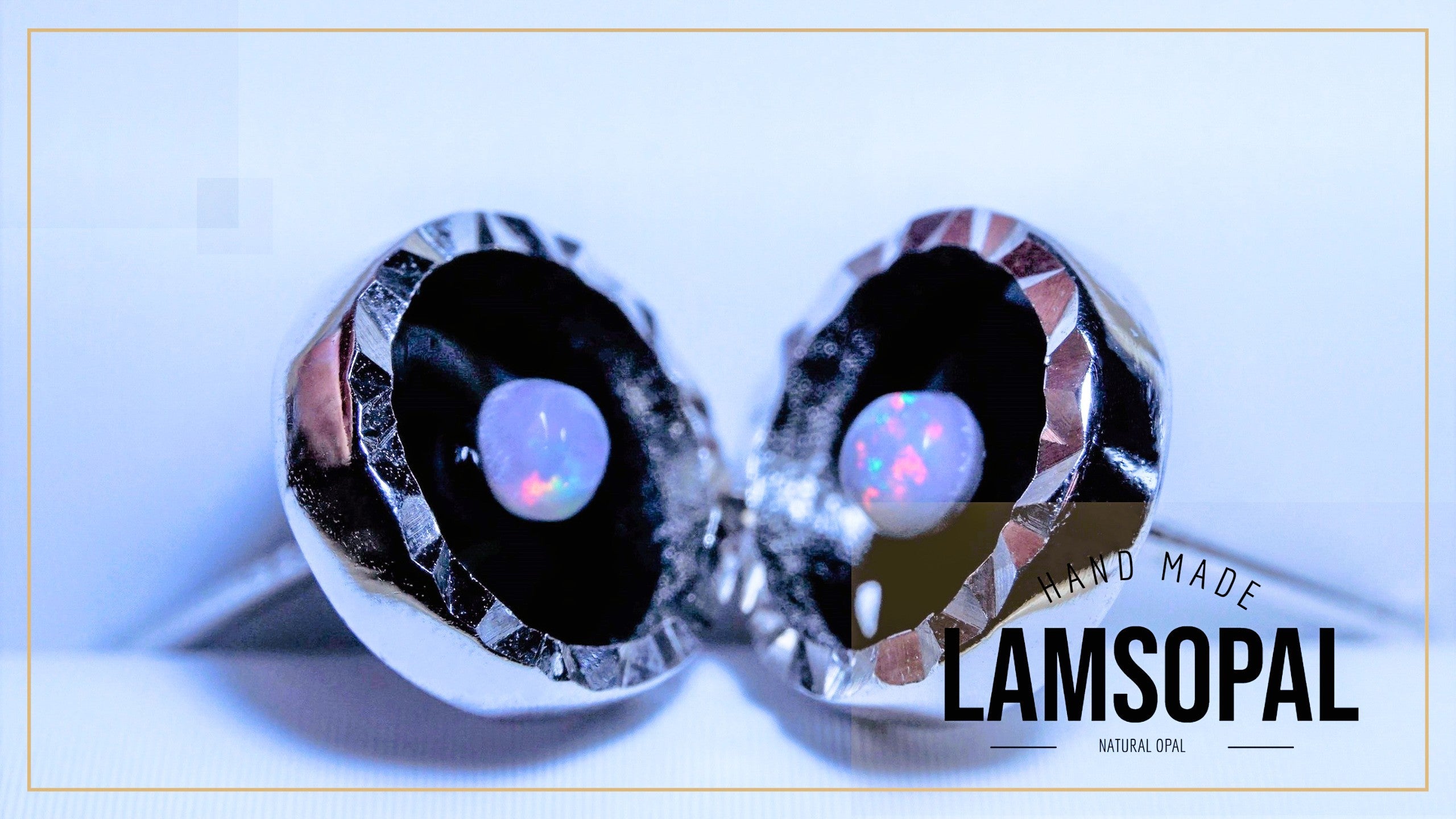 A pair of silver-toned Lamsopal cufflinks with faceted black inlays and natural opal centers, displayed on a light blue background with a 'LAMSOPAL' brand overlay.