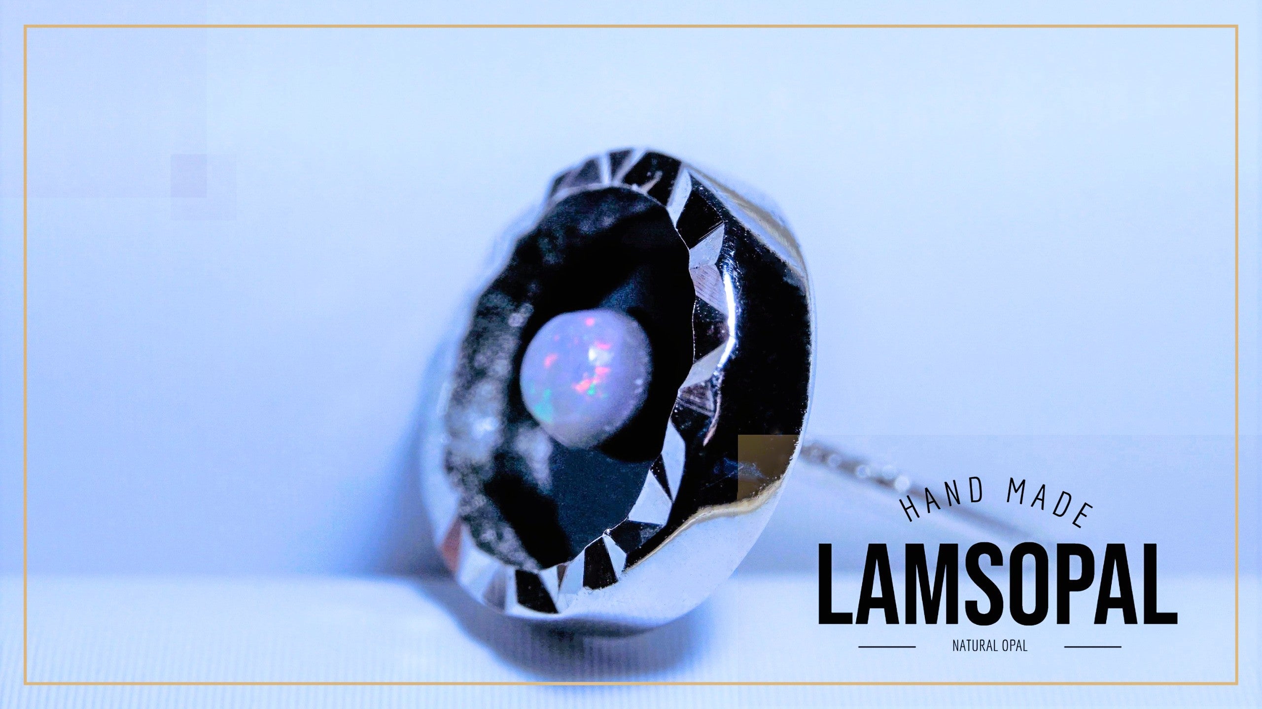 A faceted silver pendant featuring a round natural opal gemstone with iridescent colors, displayed on a light blue background with 'HAND MADE LAMSOPAL' text overlay.