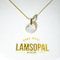 A gold chain necklace with a round iridescent moonstone pendant, displayed on a white backing card with gold foil text reading 'HAND MADE LAMSOPAL'.