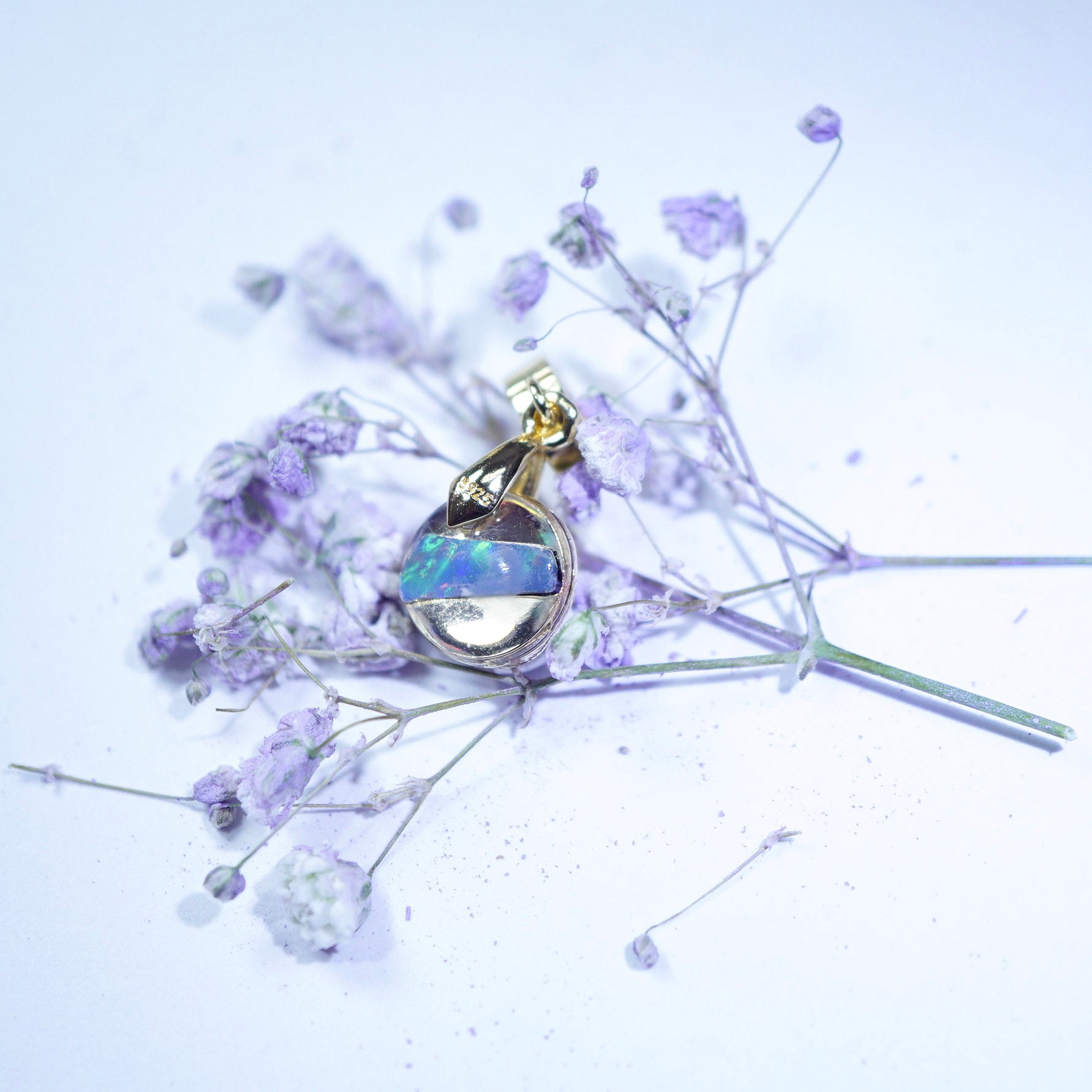 Jewelry pendant with opal gemstone on a white background