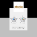 Snowflake opal earrings on a Lamsopal branded card with a gray background
