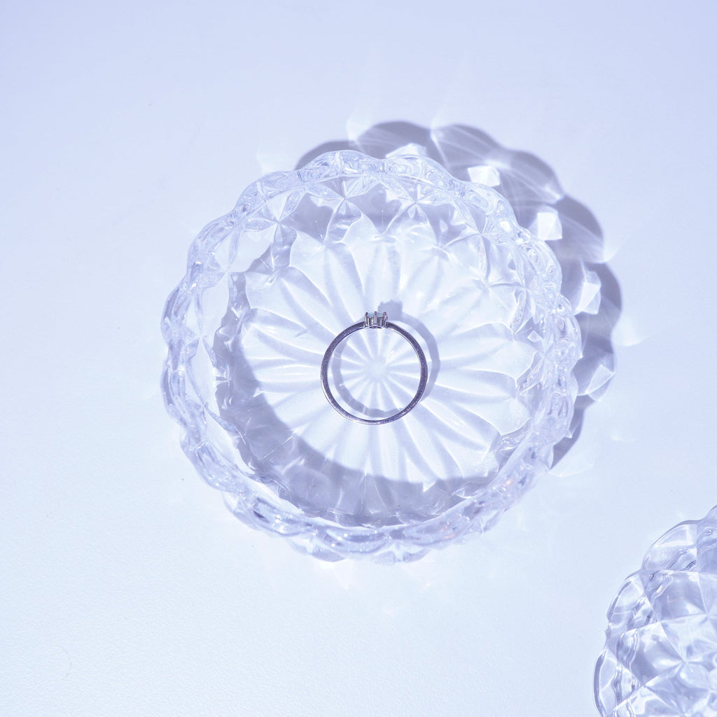 Crystal Opal Ring in the rystal dish with floral design on a light purple background