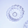 Crystal Opal Ring in the rystal dish with floral design on a light purple background