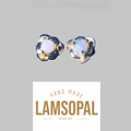 A pair of handmade Lamsopal natural opal stud earrings with textured gold and silver settings, shown above a white brand card on a solid gray background.