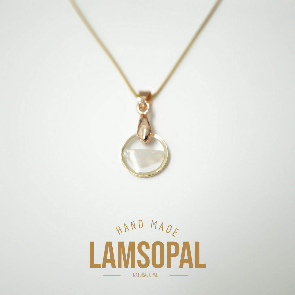 A delicate gold necklace with a teardrop-shaped clear gemstone pendant, displayed on a clean white background with 'HAND MADE LAMSOPAL' text below.