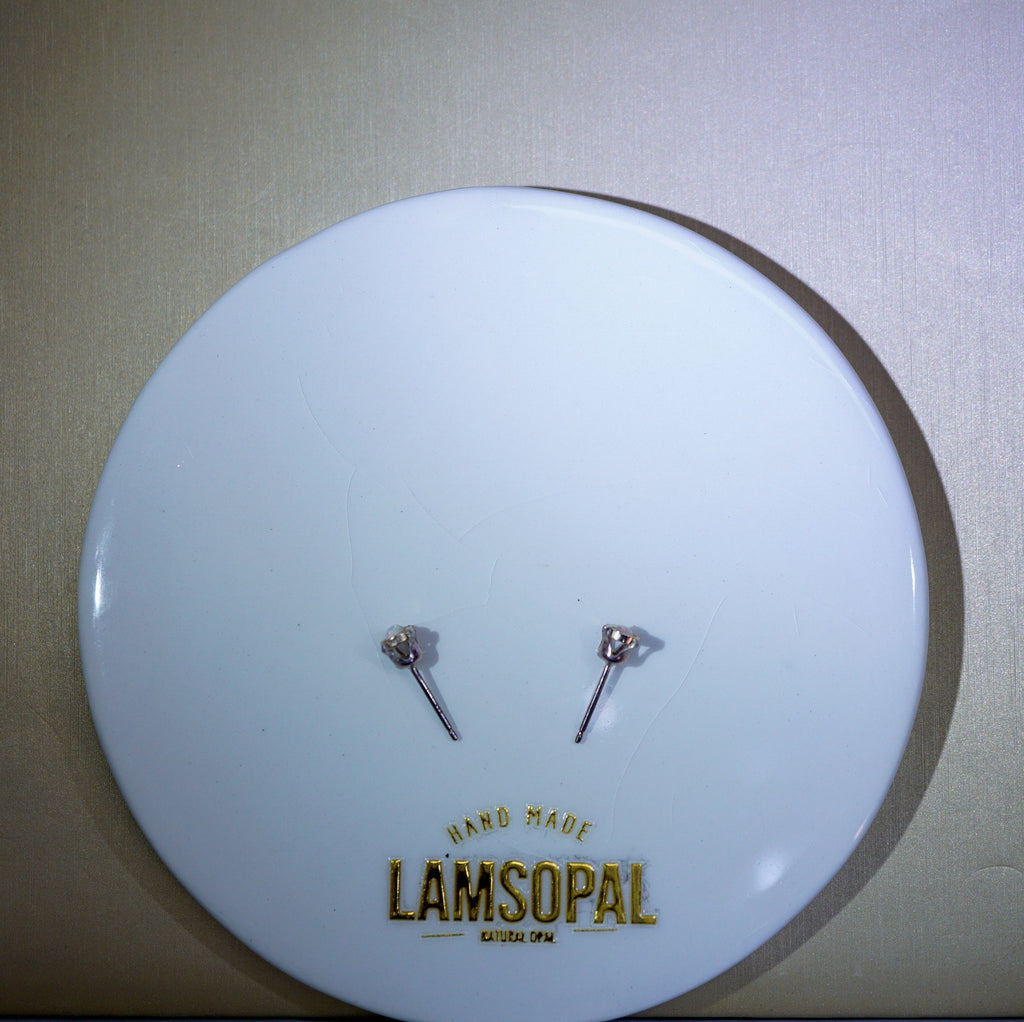 A pair of silver-toned stud earrings displayed on a round white backing card printed with the brand name 'LAMSOPAL' and 'HAND MADE MUSLIM JEWELRY' in gold lettering, set against a neutral beige background.