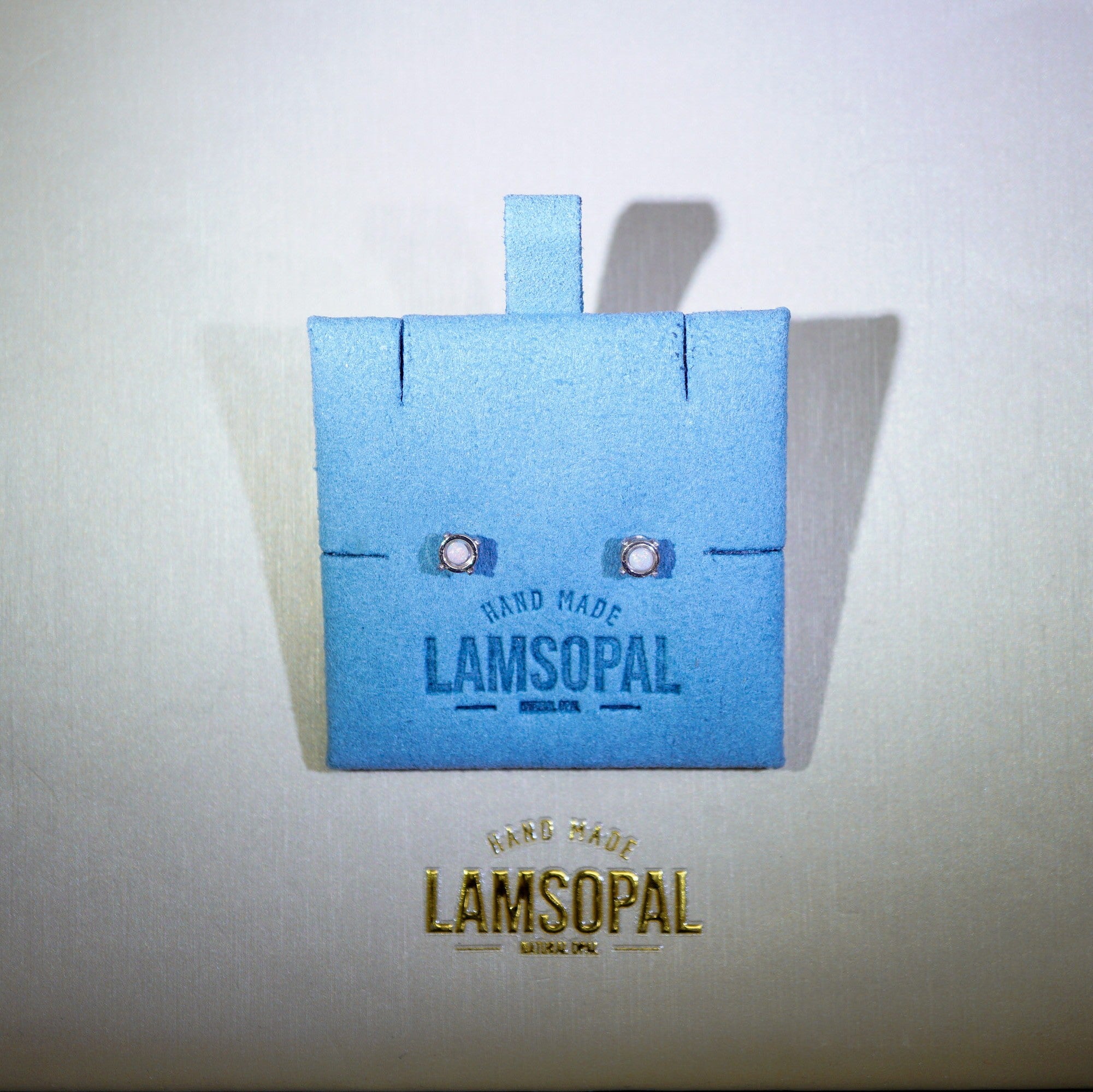 A light blue Lamsopal handmade card holder or decorative box with two small white gem-like accents, shown on a light beige background with the Lamsopal logo printed below.